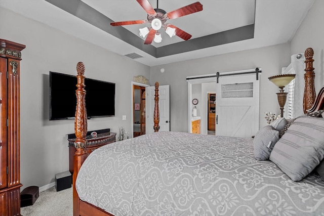 701 E Bayshore Dr, Ozark, MO 65721 - carpeted bedroom with a barn door, a tray ceiling, ensuite bathroom, and ceiling fan