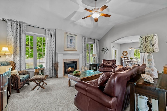 701 E Bayshore Dr, Ozark, MO 65721 - carpeted living room featuring a ceiling fan, a tile fireplace, arched walkways, vaulted ceiling, and a chandelier