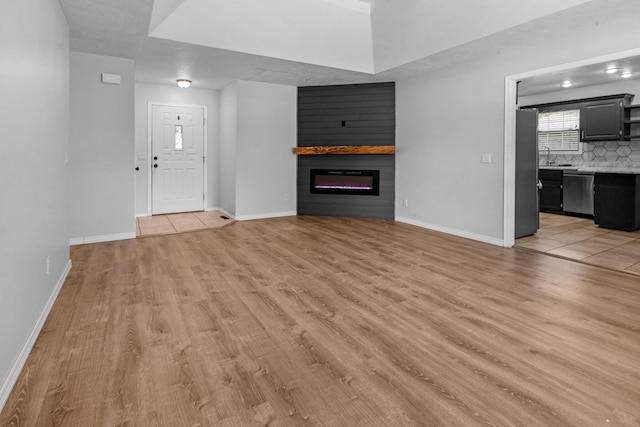 519 N Lynette Ave, Republic, MO 65738 - unfurnished living room featuring light wood-type flooring and a large fireplace