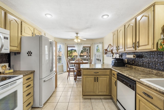 3045 S Palisades Dr, Springfield, MO 65807 - kitchen with white appliances, a ceiling fan, a peninsula, light tile patterned flooring, and decorative backsplash