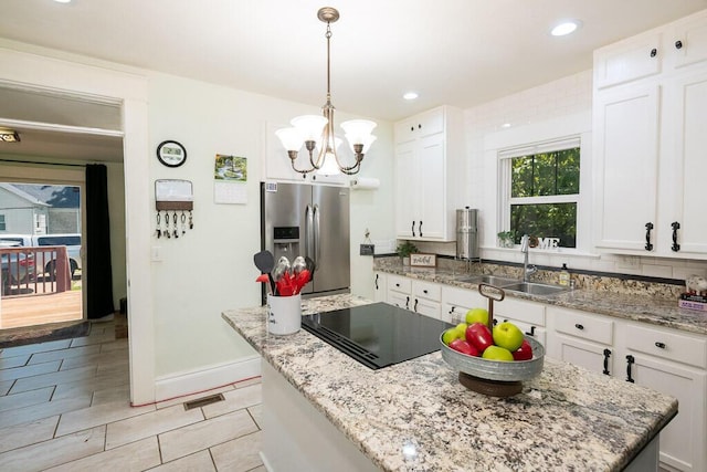 628 W Lynn St, Springfield, MO 65802 - kitchen featuring stainless steel refrigerator with ice dispenser, black electric stovetop, white cabinets, a chandelier, and hanging light fixtures