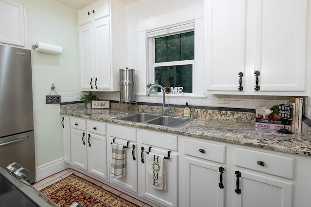 628 W Lynn St, Springfield, MO 65802 - kitchen with freestanding refrigerator, white cabinetry, and light stone counters