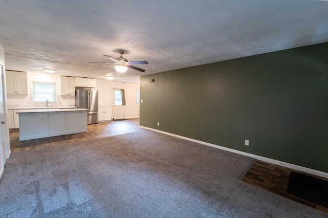 1520 E Seminole St, Springfield, MO 65804 - unfurnished living room featuring ceiling fan, dark wood-type flooring, and dark colored carpet