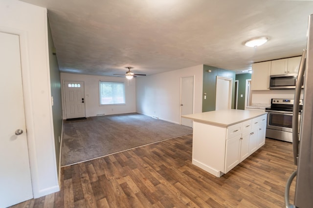 1520 E Seminole St, Springfield, MO 65804 - kitchen featuring stainless steel appliances, white cabinets, a ceiling fan, dark wood-style flooring, and light countertops