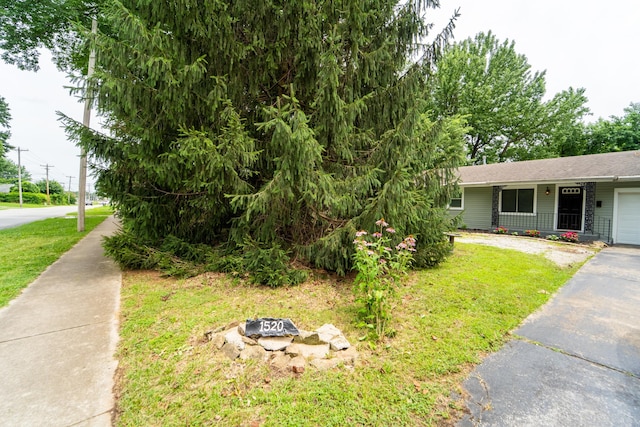 1520 E Seminole St, Springfield, MO 65804 - view of front of property with a front yard, a garage, asphalt driveway, and a fire pit