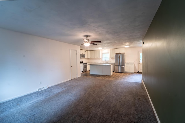 1520 E Seminole St, Springfield, MO 65804 - unfurnished living room featuring ceiling fan and dark colored carpet