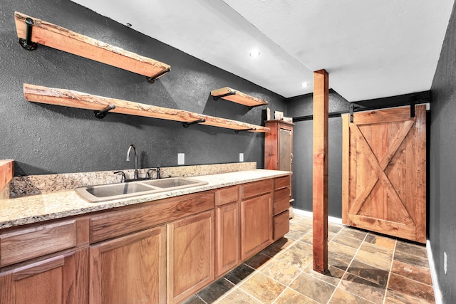 1604 E Sycamore St, Ozark, MO 65721 - kitchen with open shelves, a barn door, stone tile flooring, a textured wall, and recessed lighting