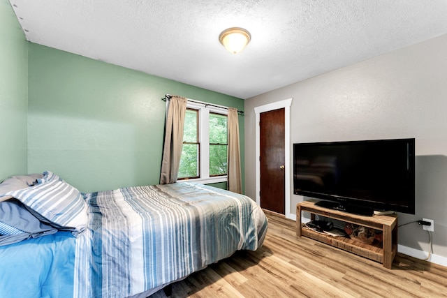 1604 E Sycamore St, Ozark, MO 65721 - bedroom with light wood finished floors and a textured ceiling