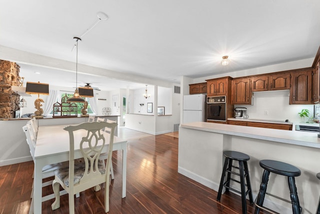 189 Pierce Pl, Forsyth, MO 65653 - kitchen with freestanding refrigerator, oven, light countertops, a breakfast bar, and dark wood-type flooring