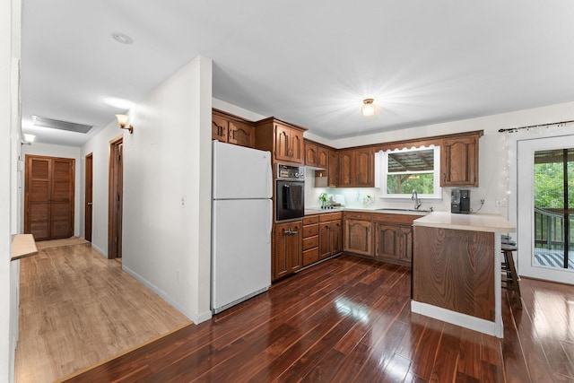 189 Pierce Pl, Forsyth, MO 65653 - kitchen with freestanding refrigerator, oven, dark wood-type flooring, and light countertops