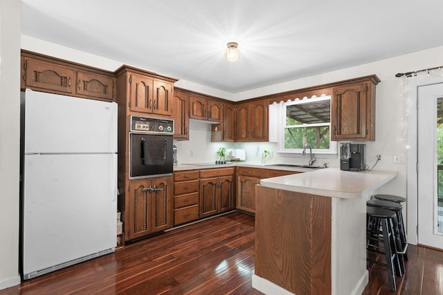 189 Pierce Pl, Forsyth, MO 65653 - kitchen featuring freestanding refrigerator, black oven, dark wood-style floors, and a peninsula