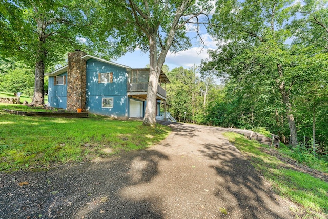 189 Pierce Pl, Forsyth, MO 65653 - view of front facade featuring a chimney, driveway, a sunroom, and a front yard
