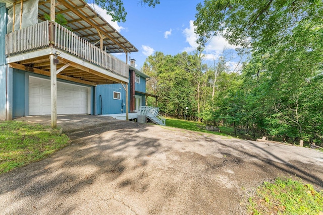189 Pierce Pl, Forsyth, MO 65653 - view of home's exterior featuring asphalt driveway, a balcony, a chimney, and a garage