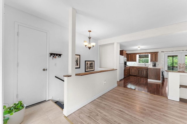 189 Pierce Pl, Forsyth, MO 65653 - kitchen featuring freestanding refrigerator, light countertops, a chandelier, wood finished floors, and hanging light fixtures