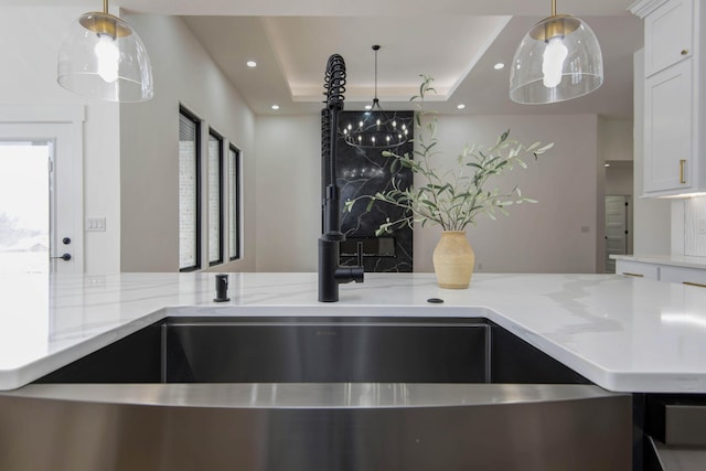 2112 N Sun Valley Dr, Springfield, MO 65802 - kitchen featuring a tray ceiling, light stone counters, decorative light fixtures, white cabinets, and recessed lighting
