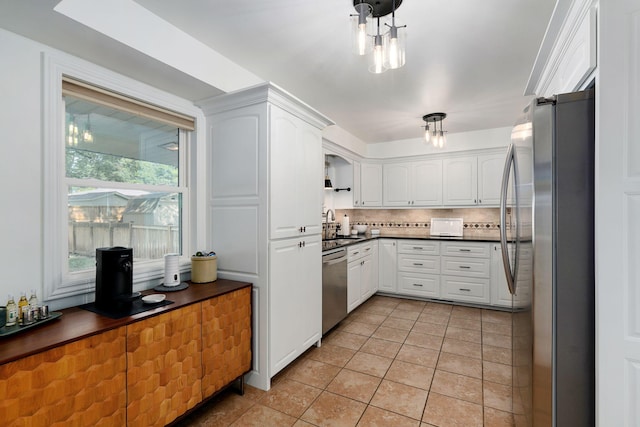 1923 S Cedarbrook Ave, Springfield, MO 65804 - kitchen featuring appliances with stainless steel finishes, dark countertops, white cabinetry, decorative backsplash, and light tile patterned floors
