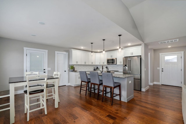 917 W Charlotte St, Republic, MO 65738 - kitchen with appliances with stainless steel finishes, a center island, tasteful backsplash, white cabinetry, and recessed lighting