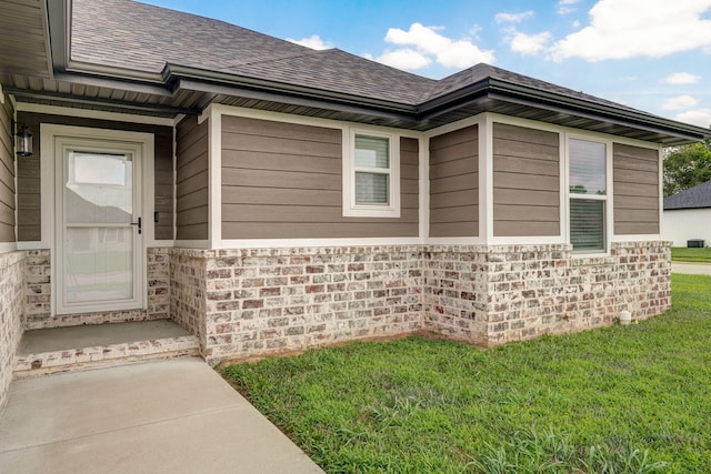 917 W Charlotte St, Republic, MO 65738 - doorway to property featuring a shingled roof, a lawn, and stone siding