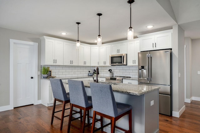 917 W Charlotte St, Republic, MO 65738 - kitchen featuring appliances with stainless steel finishes, backsplash, white cabinetry, a breakfast bar, and recessed lighting