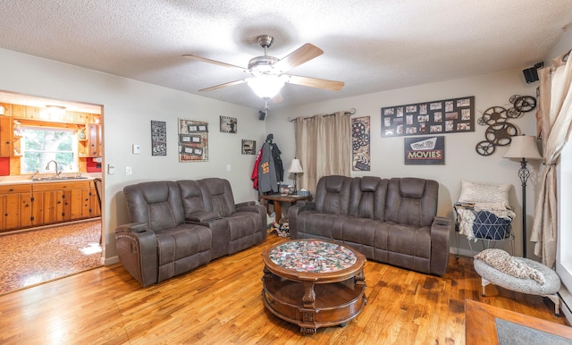 11240 State Hwy E, Rolla, MO 65401 - living room featuring light wood finished floors, a ceiling fan, and a textured ceiling
