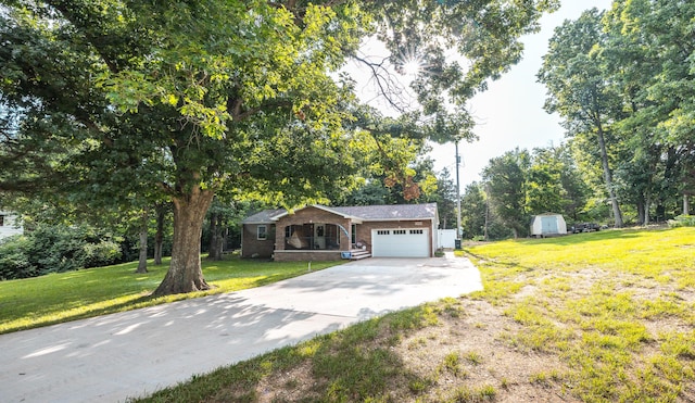11240 State Hwy E, Rolla, MO 65401 - view of front of home with a garage, concrete driveway, a front lawn, a storage unit, and brick siding