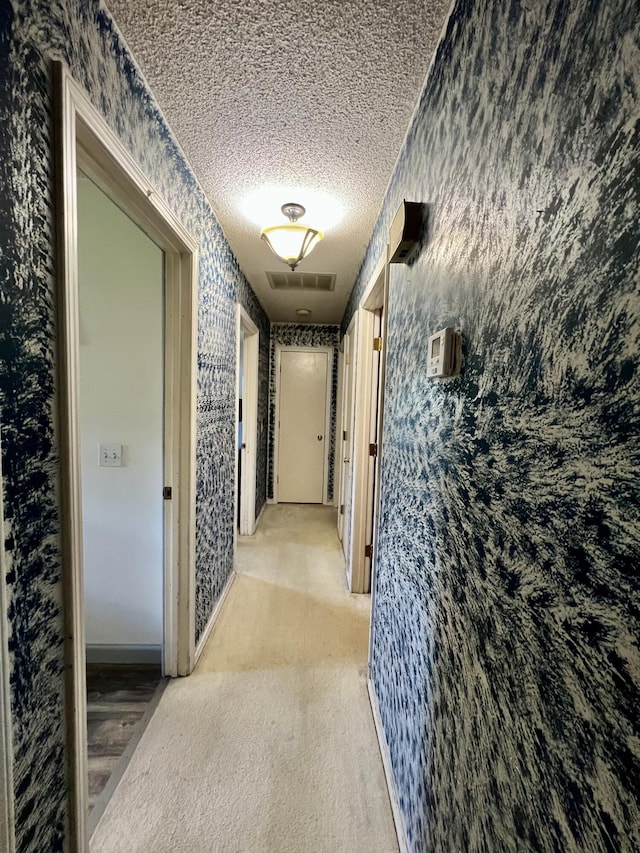 817 Fillmore St, Mount Vernon, MO 65712 - hallway featuring wallpapered walls, a textured ceiling, and carpet floors