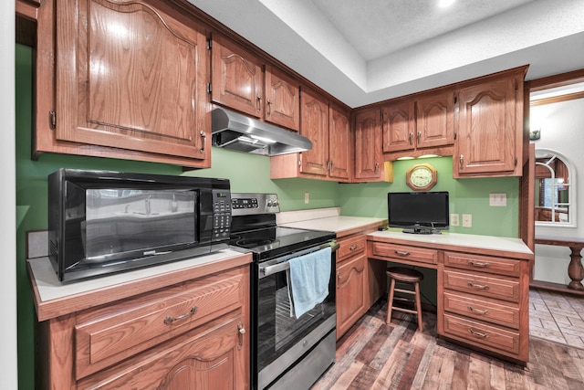 1011 W Tracy St, Springfield, MO 65807 - kitchen featuring stainless steel range with electric cooktop, under cabinet range hood, black microwave, built in study area, and light countertops