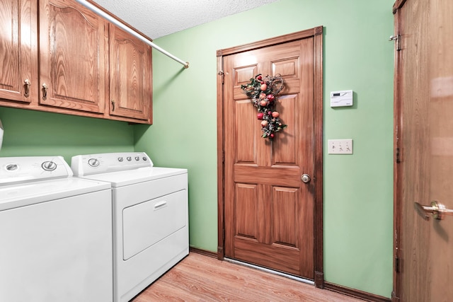 1011 W Tracy St, Springfield, MO 65807 - washroom with separate washer and dryer, cabinet space, light wood-style floors, and a textured ceiling