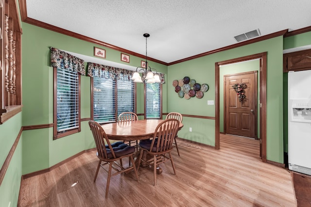 1011 W Tracy St, Springfield, MO 65807 - dining room with light wood-style floors, ornamental molding, a chandelier, and a textured ceiling