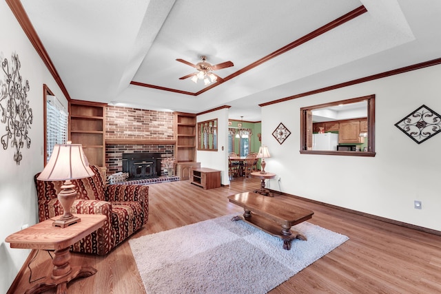 1011 W Tracy St, Springfield, MO 65807 - living room with a raised ceiling, ceiling fan, wood finished floors, crown molding, and built in shelves