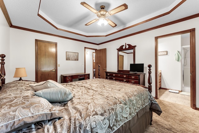 1011 W Tracy St, Springfield, MO 65807 - carpeted bedroom with a tray ceiling, ornamental molding, ensuite bathroom, and a ceiling fan