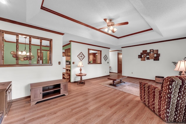 1011 W Tracy St, Springfield, MO 65807 - living room featuring a raised ceiling, ceiling fan, light wood-style floors, a chandelier, and ornamental molding