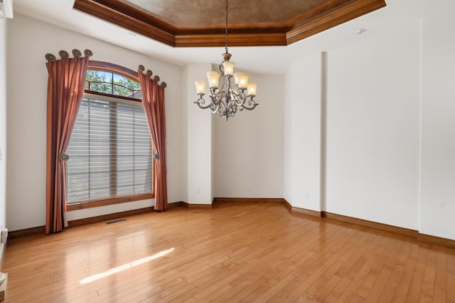 744 Seven Pines Dr, Saddlebrooke, MO 65630 - unfurnished room featuring a raised ceiling, a chandelier, light wood-style flooring, and ornamental molding