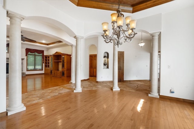 744 Seven Pines Dr, Saddlebrooke, MO 65630 - unfurnished dining area featuring a raised ceiling, ornamental molding, light wood-style floors, a chandelier, and arched walkways