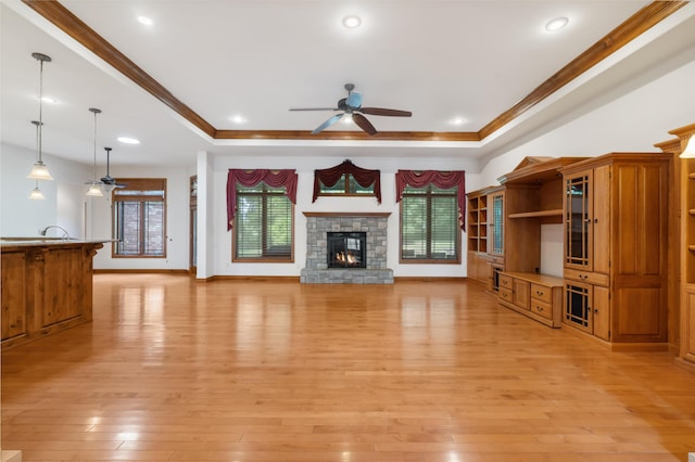 744 Seven Pines Dr, Saddlebrooke, MO 65630 - unfurnished living room featuring a ceiling fan, a raised ceiling, healthy amount of natural light, light wood-type flooring, and ornamental molding