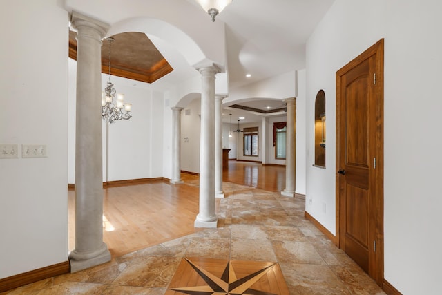 744 Seven Pines Dr, Saddlebrooke, MO 65630 - foyer with a raised ceiling, decorative columns, light stone finish floors, ornamental molding, and a chandelier