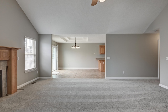 4406 W 28th St, Joplin, MO 64804 - unfurnished living room featuring light carpet, a tiled fireplace, a chandelier, a ceiling fan, and a raised ceiling