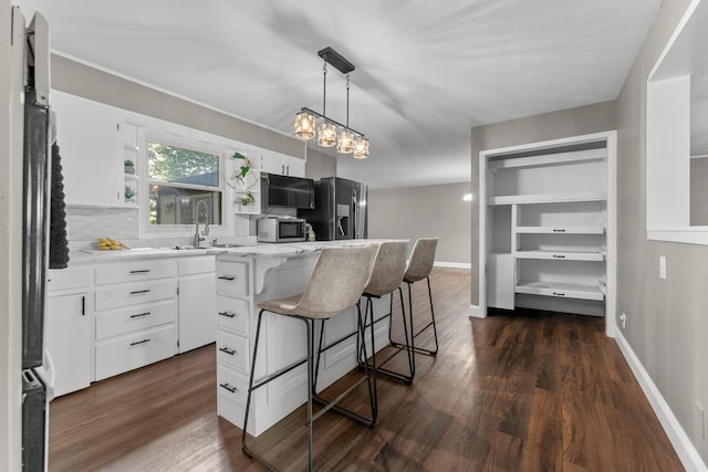 522 S Belcrest Ave, Springfield, MO 65802 - kitchen featuring refrigerator with ice dispenser, dark wood finished floors, and white cabinetry