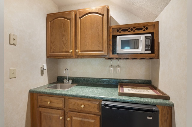 3314 Winged Foot Dr, Nixa, MO 65714 - kitchen featuring white microwave, dark countertops, lofted ceiling, fridge, and brown cabinetry