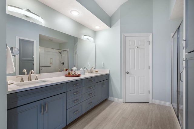 3314 Winged Foot Dr, Nixa, MO 65714 - bathroom with a stall shower, double vanity, wood finished floors, and vaulted ceiling