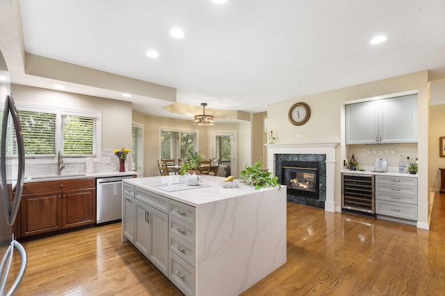 3314 Winged Foot Dr, Nixa, MO 65714 - kitchen with wine cooler, stainless steel dishwasher, a premium fireplace, a center island, and light wood-type flooring