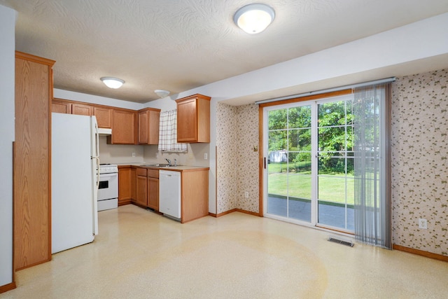 2816 N Pierce Ave, Springfield, MO 65803 - kitchen with white appliances, wallpapered walls, light floors, light countertops, and extractor fan