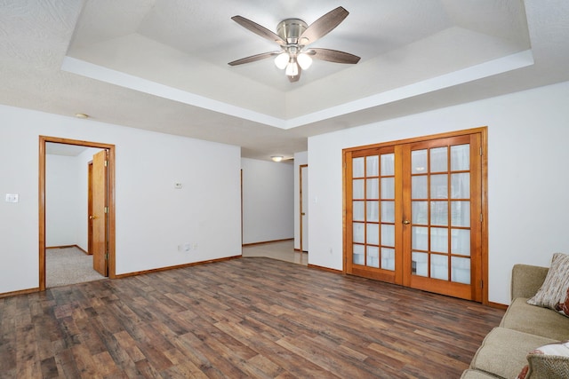 2816 N Pierce Ave, Springfield, MO 65803 - unfurnished living room with a tray ceiling, wood finished floors, french doors, and ceiling fan