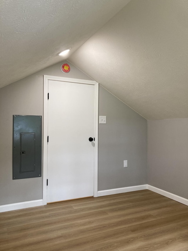 507 W Clouse St, Mountain Grove, MO 65711 - additional living space with electric panel, wood finished floors, vaulted ceiling, and a textured ceiling