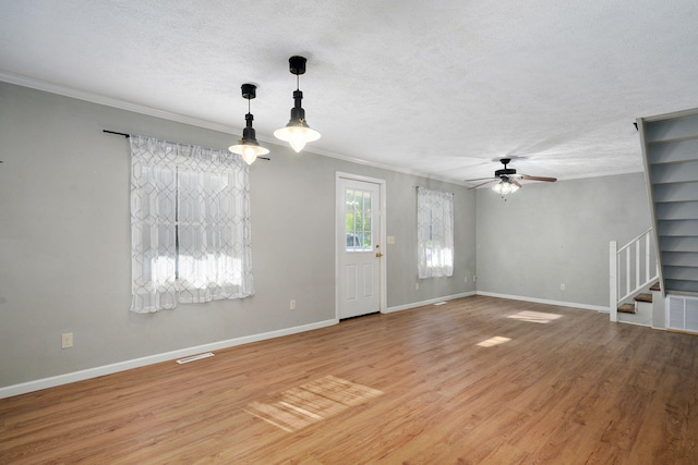 533 N Main St, Republic, MO 65738 - unfurnished living room with crown molding, a textured ceiling, stairway, a ceiling fan, and light wood-type flooring