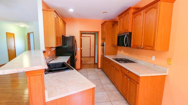 5546 S Aspen Dr, Battlefield, MO 65619 - kitchen with appliances with stainless steel finishes, a peninsula, light countertops, light tile patterned flooring, and brown cabinetry