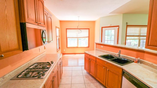5546 S Aspen Dr, Battlefield, MO 65619 - kitchen featuring appliances with stainless steel finishes, light countertops, brown cabinetry, light tile patterned flooring, and hanging light fixtures