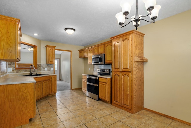 844 S Natalie Ave, Springfield, MO 65802 - kitchen with stainless steel appliances, decorative backsplash, a chandelier, brown cabinets, and light countertops