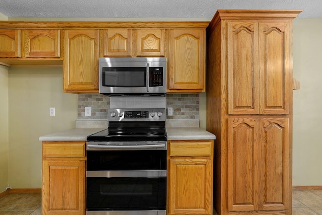 844 S Natalie Ave, Springfield, MO 65802 - kitchen with appliances with stainless steel finishes, light countertops, backsplash, and light tile patterned flooring