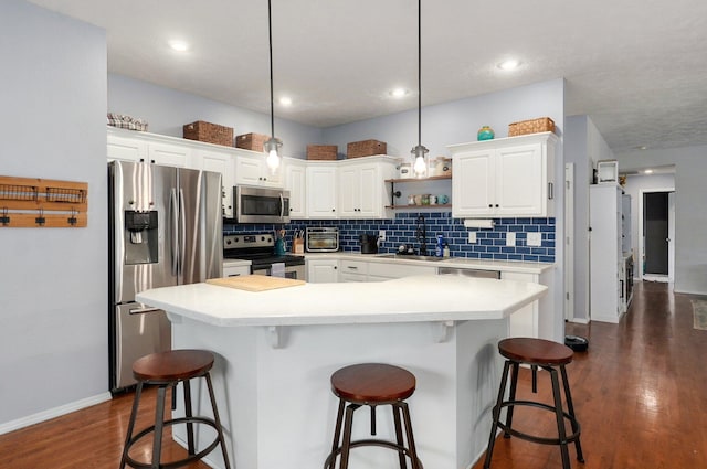 5055 E Cherry Pl, Springfield, MO 65809 - kitchen featuring stainless steel appliances, a breakfast bar, backsplash, dark wood finished floors, and recessed lighting